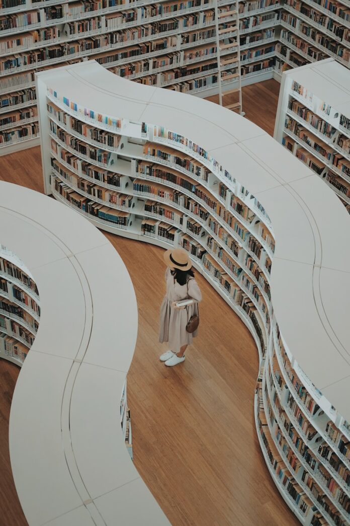 Photo by Arif Riyanto woman standing on bookstore