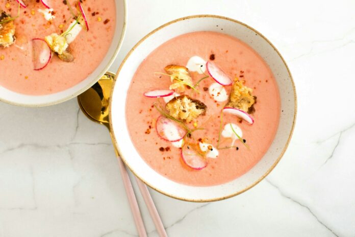 a bowl of soup with chopsticks