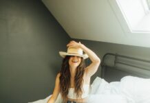 새해 맞이, 더 나은 자기 관리 비법 woman sitting on bed holding her hat