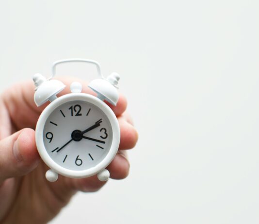 시간 관리의 비법, ‘블록 타임’ 활용하기 person holding white mini bell alarmclock