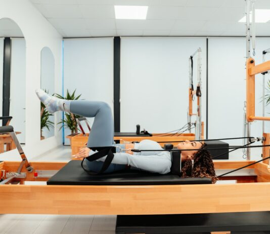 에너지 회복, 필라테스로 만성 피로 극복하기 a woman is doing a pivot on a pivot machine