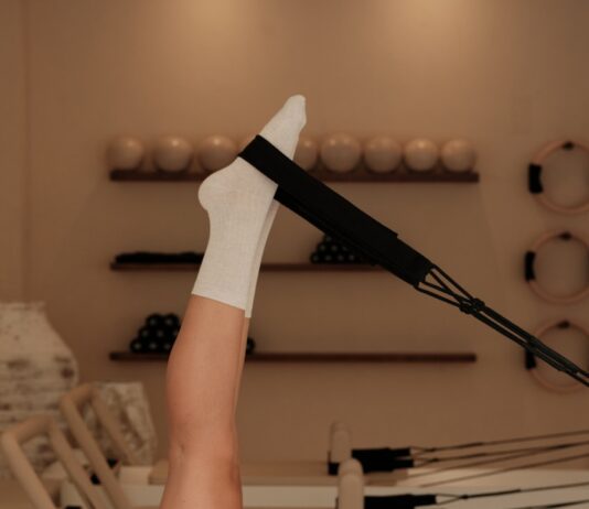 필라테스 열풍, 코어 강화와 마음 건강까지 잡는 건강 트렌드로 자리잡다 Woman does pilates exercise on a reformer machine.