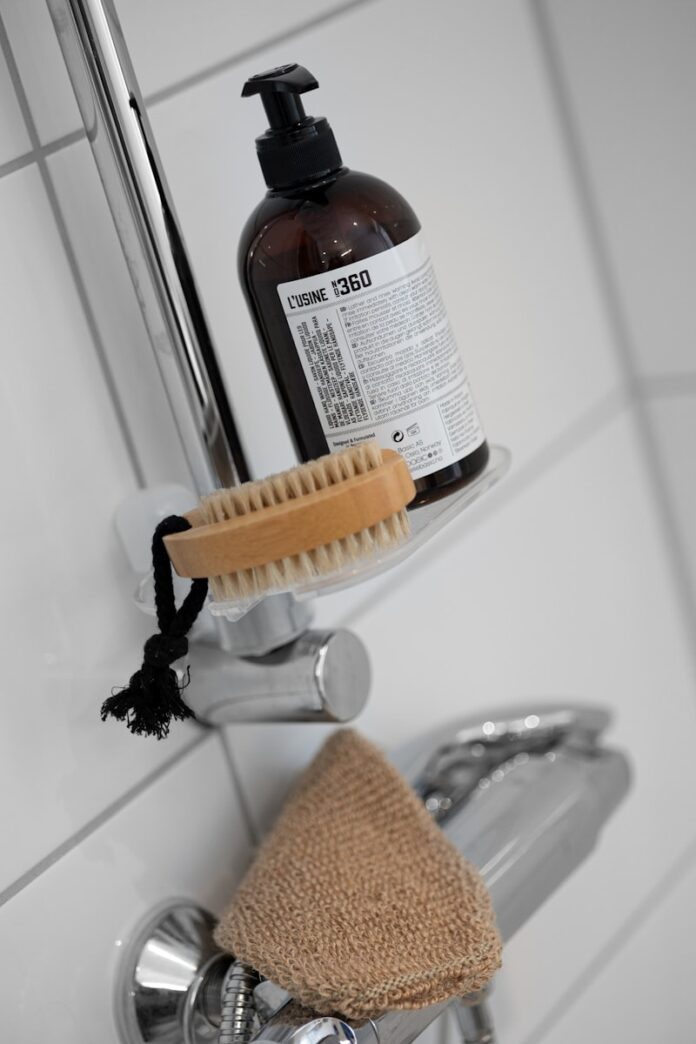 Photo by Lisa Anna A bottle of soap sitting on top of a faucet