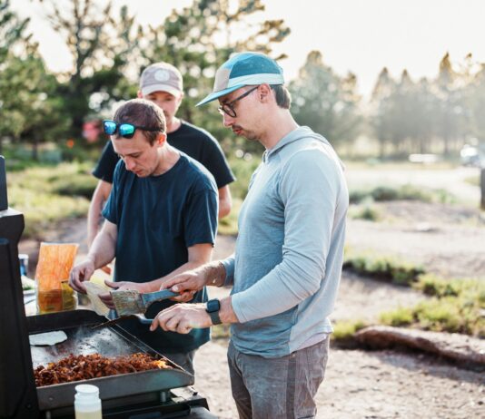 바쁜 일상 속 ‘마음 챙김 식사’ 실천법…행복한 식탁 만드는 작은 습관들 Three men cooking food on an outdoor grill.